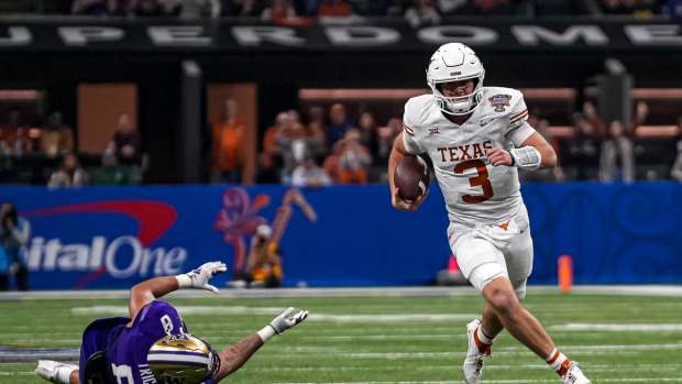 Texas Longhorns quarterback Quinn Ewers (3) evades a tackle by Washington edge Bralen Trice (8) during the Sugar Bowl College Football Playoff semifinals game at the Caesars Superdome on Monday, Jan. 1, 2024 in New Orleans, Louisiana.