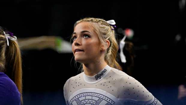 Apr 20, 2024; Fort Worth, TX, USA; LSU Tigers gymnast Olivia Dunne watches as LSU Tigers gymnast Haleigh Bryant performs on uneven bars during the 2024 Womens National Gymnastics Championship at Dickies Arena.
