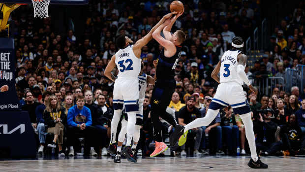 May 6, 2024; Denver, Colorado, USA; Denver Nuggets center Nikola Jokic (15) attempts a shot as Minnesota Timberwolves center Karl-Anthony Towns (32) defends in the first quarter during game two of the second round for the 2024 NBA playoffs at Ball Arena.