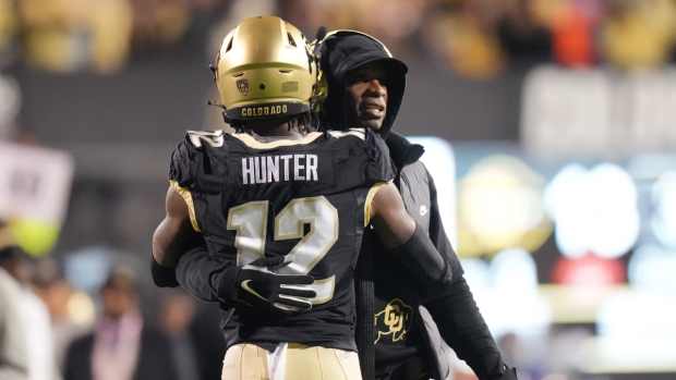 Colorado Buffaloes wide receiver Travis Hunter (12) is congratulated for his touchdown by head coach Deion Sanders in the first quarter against the Stanford Cardinal at Folsom Field.
