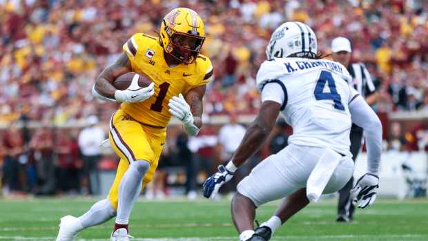 Sep 14, 2024; Minneapolis, Minnesota, USA; Minnesota Golden Gophers running back Darius Taylor (1) runs the ball as Nevada Wolf Pack safety Kitan Crawford (4) defends during the first half at Huntington Bank Stadium.