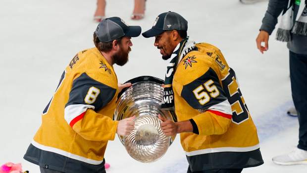 Vegas Golden Knights forward Phil Kessel (8) hands the Stanley Cup to forward Keegan Kolesar (55) after winning the 2023 championship.