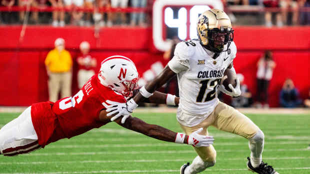 Sep 7, 2024; Lincoln, Nebraska, USA; Colorado Buffaloes wide receiver Travis Hunter (12) stiff arms Nebraska Cornhuskers defensive back Tommi Hill (6) during the second quarter at Memorial Stadium.