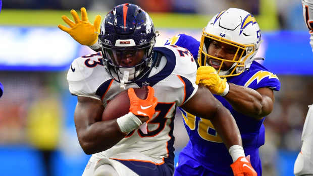 Dec 10, 2023; Inglewood, California, USA; Denver Broncos running back Javonte Williams (33) runs the ball against Los Angeles Chargers linebacker Justin Hollins (58) during the second half at SoFi Stadium. Mandatory Credit: Gary A. Vasquez-USA TODAY Sports  