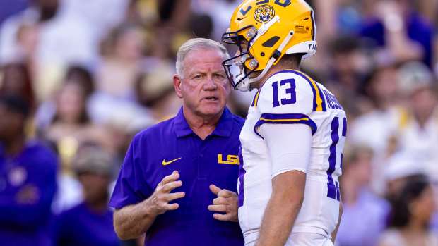 LSU Tigers quarterback Garrett Nussmeier (13) talks to head coach Brian Kelly.