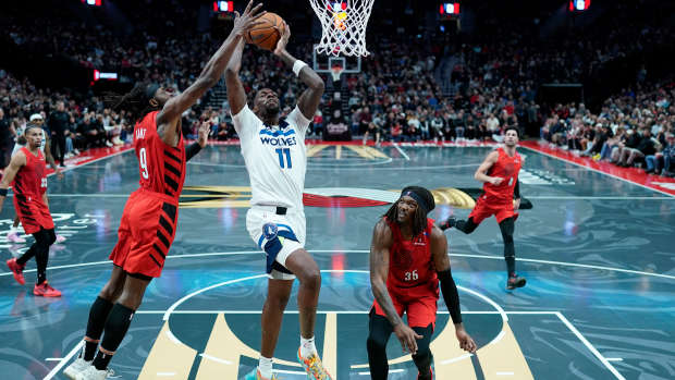 Nov 12, 2024; Portland, Oregon, USA; Minnesota Timberwolves center Naz Reid (11) goes up for a dunk against Portland Trail Blazers small forward Jerami Grant (9) during the first half at Moda Center.