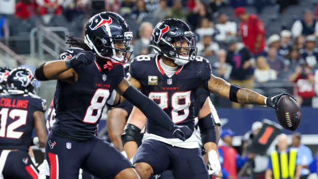 Houston Texans running back Joe Mixon (28) celebrates a touchdown with wide receiver John Metchie III (8) against the Dallas Cowboys.