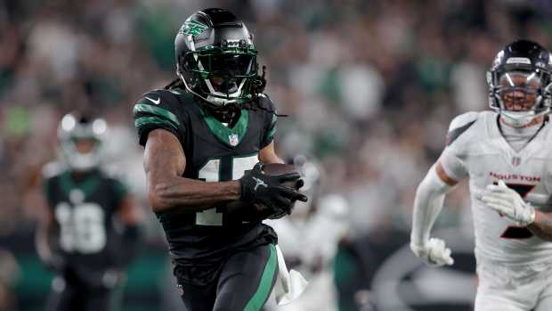 New York Jets wide receiver Davante Adams runs after catching a pass against the Houston Texans.