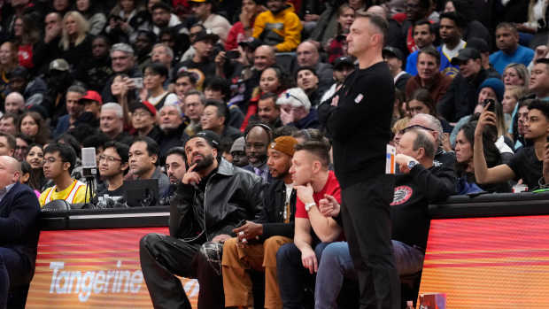 Jan 13, 2025; Toronto, Ontario, CAN; Recording artist Drake (left) looks up at the scoreboard as Toronto Raptors head coach Darko Rajakovic (right) watches the action against the Golden State Warriors during the second half at Scotiabank Arena. Mandatory Credit: John E. Sokolowski-Imagn Images