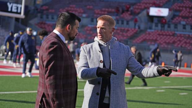 Ohio State University football coach Ryan Day talks with broadcaster Joel Klatt prior to the Michigan game.