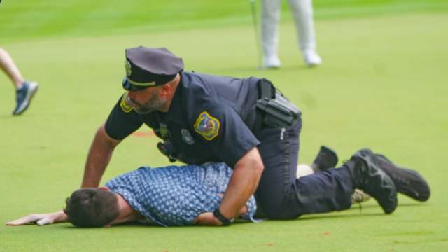 Jun 23, 2024; Cromwell, Connecticut, USA; Police tackle a protester during the final round of the Travelers Championship golf tournament on the eighteenth green at TPC River Highlands. Mandatory Credit: Gregory Fisher-USA TODAY Sports  