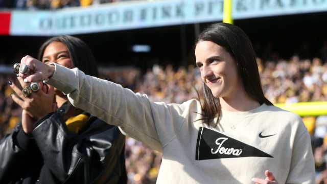 Former Iowa star Caitlin Clark shows off her rings at Kinnick Stadium.