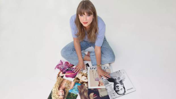 Taylor Swift posing with her first six albums 