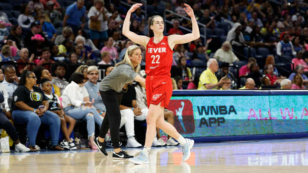 Fever star Caitlin Clark gestures to the crowd during a game against the Sky.