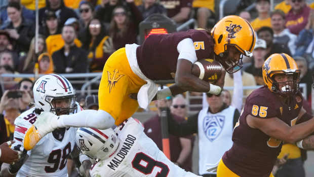 Nov 25, 2023; Tempe, Arizona, USA; Arizona State quarterback Jaden Rashada (5) is tackled by Arizona safety Gunner Maldonado (9) during the third quarter at Mountain America Stadium.