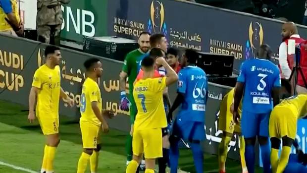 Cristiano Ronaldo pictured (center) raising his fist behind referee Mohammed Al Hoaish after being sent off during Al Nassr's 2-1 defeat by Al-Hilal in the semi-finals of the Saudi Super Cup in April 2024