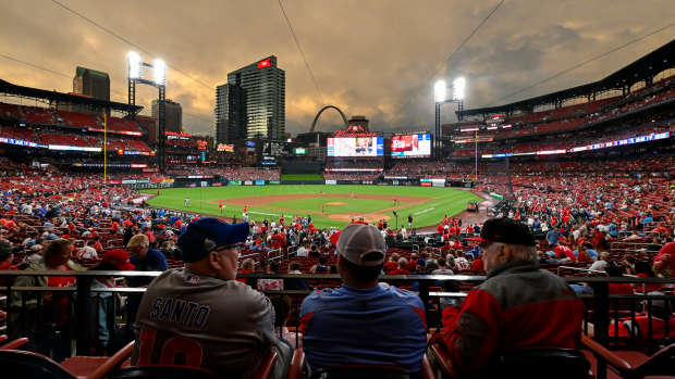 May 26, 2024; St. Louis, Missouri, USA; Fans wait in their seats as the sun sets while the grounds crew works on the field after storms in the area delayed the start of a game between the St. Louis Cardinals and the Chicago Cubs at Busch Stadium.