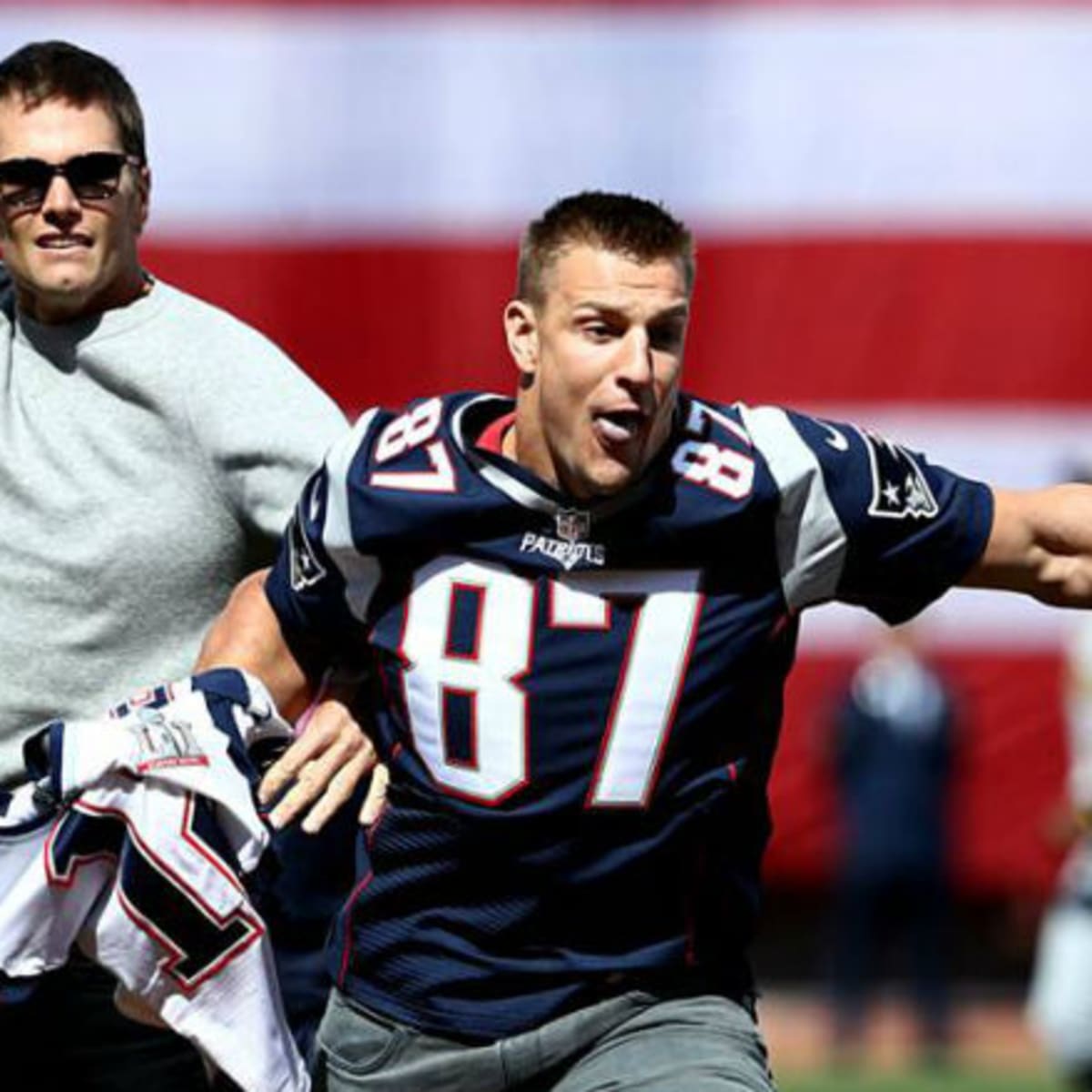 New England Patriots quarterback Tom Brady, top, playfully tackles teammate  Rob Gronkowski after he grabbed and ran with Brady's stolen and recovered  Super Bowl jersey during Boston Red Sox Home Opening Day