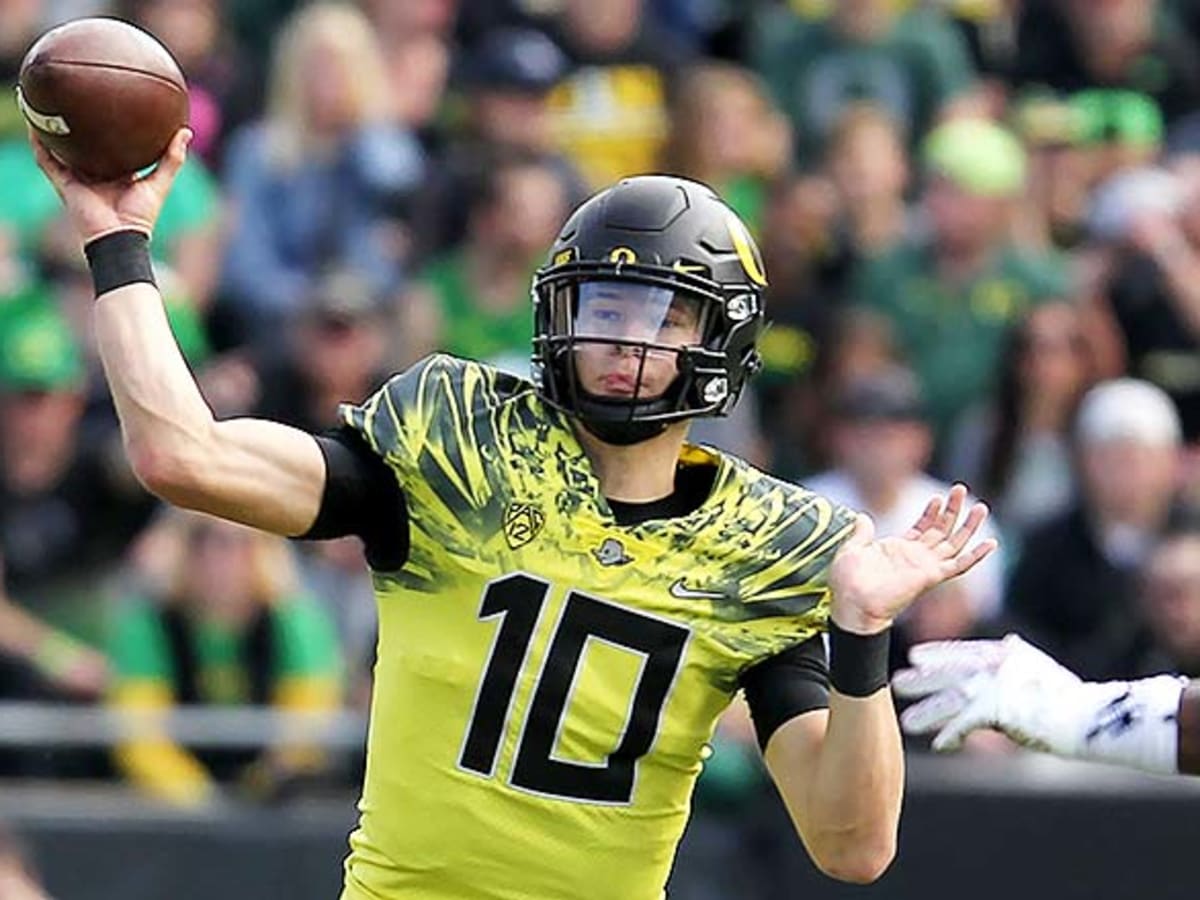 Justin Herbert Oregon Ducks Unsigned Yellow Jersey Running with Ball  Photograph