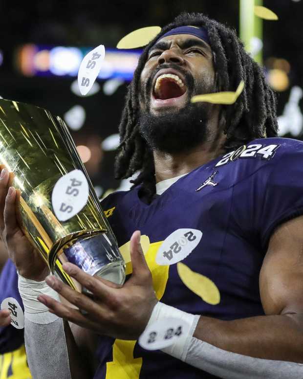 Michigan running back Donovan Edwards lifts the trophy to celebrate the 34-13 win over Washington in the national championship game at NRG Stadium in Houston on Monday, Jan. 8, 2024.