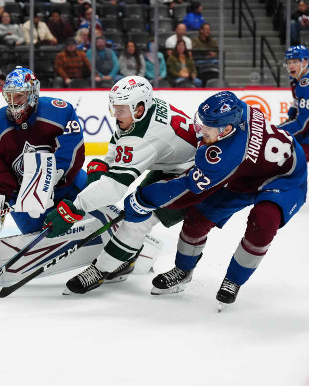Minnesota Wild right wing Vladislav Firstov (65) and Colorado Avalanche goalie Pavel Francouz (39) and defenseman Danila Zhuravyllov (82) reach for the puck in the third period at Ball Arena in Denver on Sept. 22, 2022.