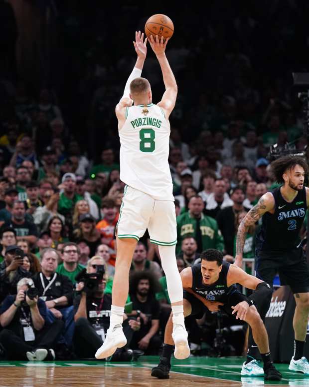 Jun 6, 2024; Boston, Massachusetts, USA; Boston Celtics center Kristaps Porzingis (8) shoots against Dallas Mavericks guard Josh Green (8) in the first quarter during game one of the 2024 NBA Finals at TD Garden.
