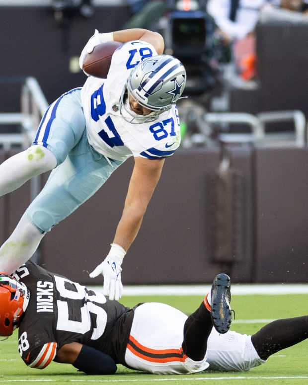 Dallas Cowboys tight end Jake Ferguson (87) falls over Cleveland Browns linebacker Jordan Hicks (58)