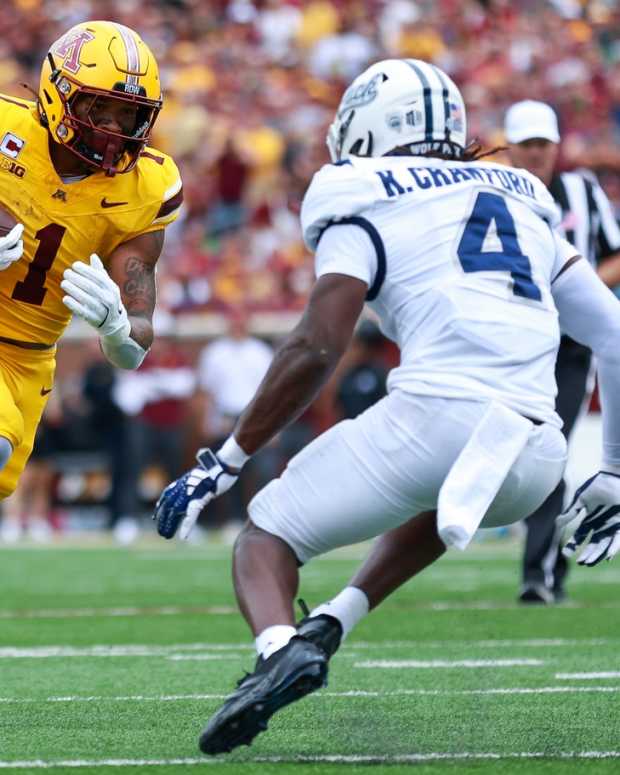 Sep 14, 2024; Minneapolis, Minnesota, USA; Minnesota Golden Gophers running back Darius Taylor (1) runs the ball as Nevada Wolf Pack safety Kitan Crawford (4) defends during the first half at Huntington Bank Stadium.