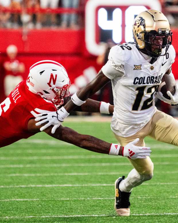 Sep 7, 2024; Lincoln, Nebraska, USA; Colorado Buffaloes wide receiver Travis Hunter (12) stiff arms Nebraska Cornhuskers defensive back Tommi Hill (6) during the second quarter at Memorial Stadium.