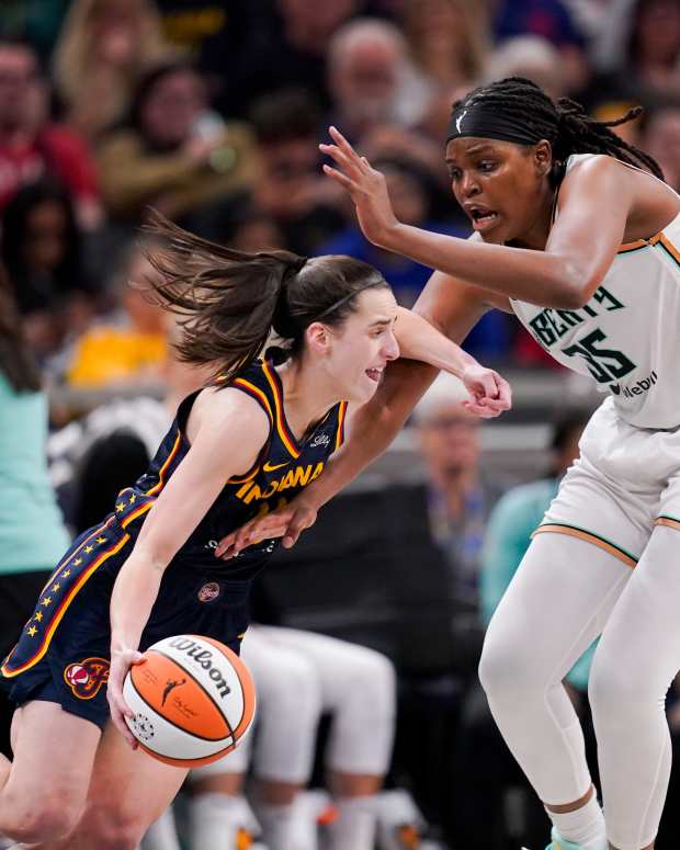 Indiana Fever guard Caitlin Clark drives past New York Liberty center Jonquel Jones.