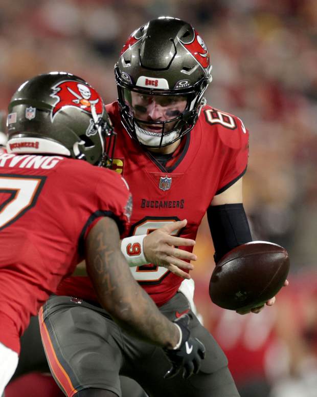 Jan 12, 2025; Tampa, Florida, USA; Tampa Bay Buccaneers quarterback Baker Mayfield (6) hands off to running back Bucky Irving (7) during the first quarter of an NFC Wild Card playoff against the Washington Commanders at Raymond James Stadium.