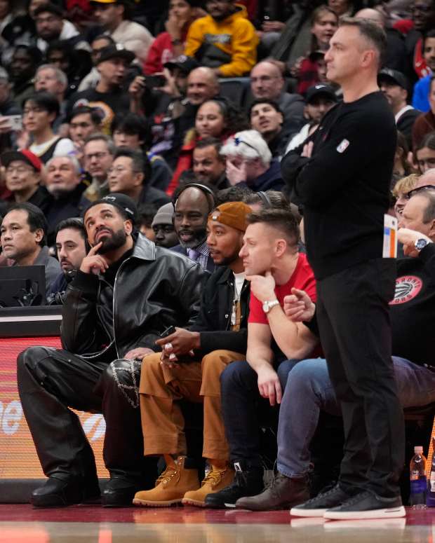 Jan 13, 2025; Toronto, Ontario, CAN; Recording artist Drake (left) looks up at the scoreboard as Toronto Raptors head coach Darko Rajakovic (right) watches the action against the Golden State Warriors during the second half at Scotiabank Arena. Mandatory Credit: John E. Sokolowski-Imagn Images