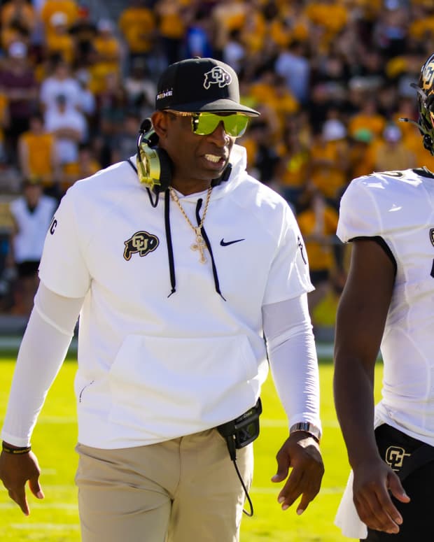 Colorado Buffaloes head coach Deion Sanders talks to quarterback Shedeur Sanders during a game against the Arizona State Sun Devils.