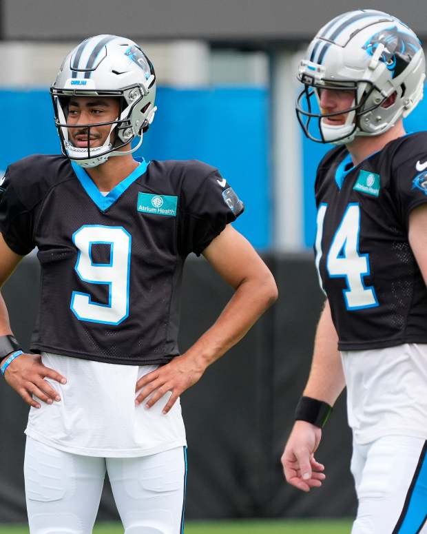 Carolina Panthers quarterback Bryce Young (9) and quarterback Andy Dalton (14) talk during training camp at Carolina Panthers Practice Fields.