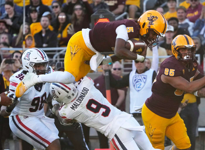 Nov 25, 2023; Tempe, Arizona, USA; Arizona State quarterback Jaden Rashada (5) is tackled by Arizona safety Gunner Maldonado (9) during the third quarter at Mountain America Stadium.