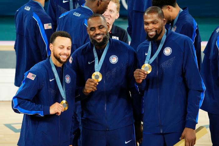 United States shooting guard Stephen Curry (4) and guard LeBron James (6) and guard Kevin Durant (7) celebrate with their gold medals on the podium after defeating France in the men's basketball gold medal game during the Paris 2024 Olympic Summer Games at Accor Arena.