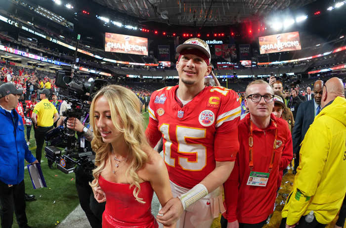 Kansas City Chiefs quarterback Patrick Mahomes (15) and his wife Brittany Mahomes walk off the field after winning Super Bowl LVIII.