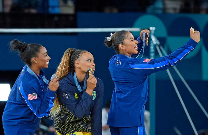 Aug 5, 2024; Paris, France; Simone Biles of the United States, Rebeca Andrade of Brazil, and Jordan Chiles of the United States with their medals on the floor exercise on day three of the gymnastics event finals during the Paris 2024 Olympic Summer Games.
