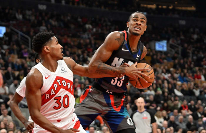Brooklyn Nets center Nic Claxton takes a rebound away from Toronto Raptors guard Ochai Agbaji during their game at Scotiabank Arena on March 25, 2024.