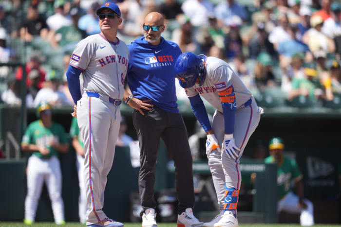 New York Mets manager Carlos Mendoza (64) stands next to center fielder Jose Siri (19)