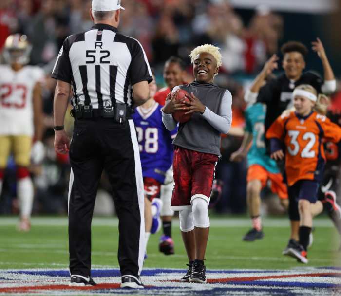 Maxwell Bunchie Young presents the game ball to referee Bill Vinovich (52) before Super Bowl LIV.