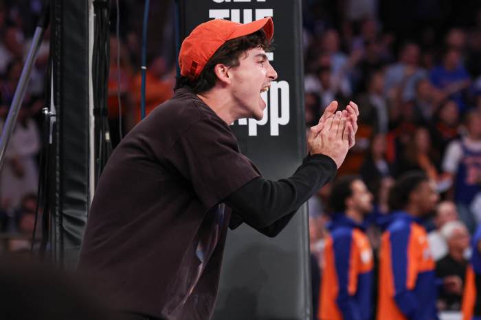 Actor and New York Knicks fan Timothee Chalamet cheers while sitting courtside.