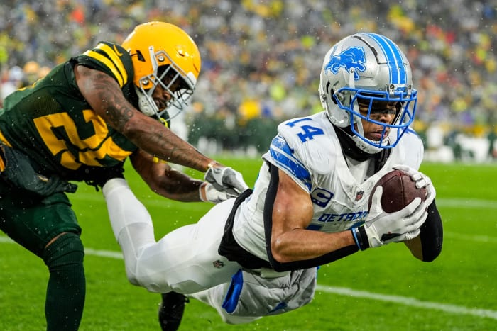 Detroit Lions WR Amon-Ra St. Brown (14) hauls in a touchdown pass over Green Bay Packers CB Keisean Nixon (25).