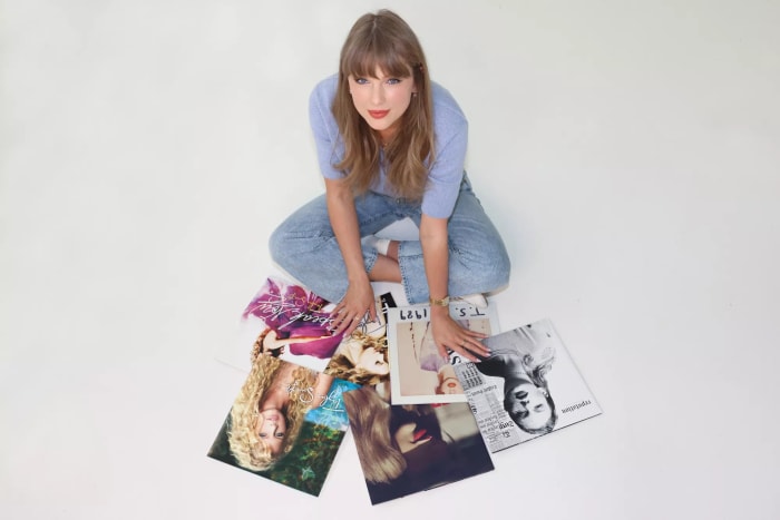 Taylor Swift posing with her first six albums