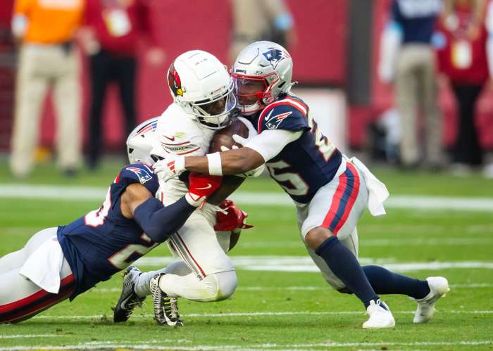 Dec 15, 2024; Glendale, Arizona, USA; New England Patriots cornerback Marcus Jones (25) tackles Arizona Cardinals wide receiver Greg Dortch (4) at State Farm Stadium.
