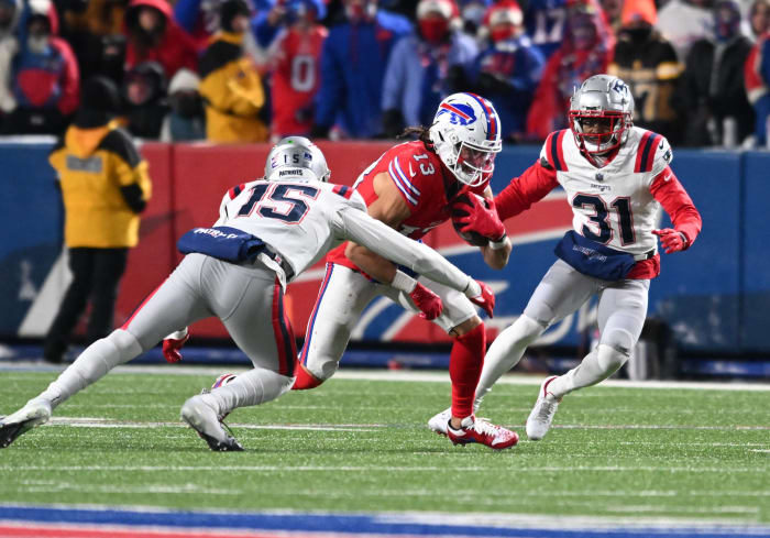Dec 22, 2024; Orchard Park, New York, USA; Buffalo Bills wide receiver Mack Hollins (13) runs between New England Patriots cornerback Jonathan Jones (31) and safety Marte Mapu (15) in the second quarter at Highmark Stadium.