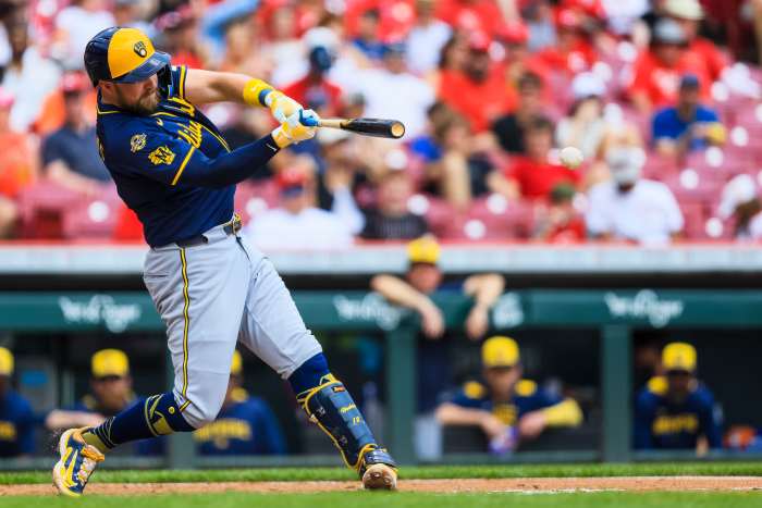 Milwaukee Brewers first baseman Rhys Hoskins (12) hits a single in the fourth inning against the Cincinnati Reds at Great American Ball Park.