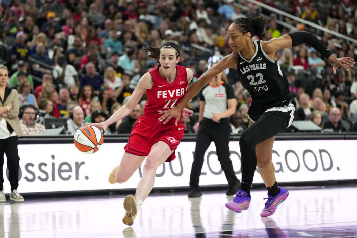 Indiana Fever guard Caitlin Clark (22) dribbles the ball against Las Vegas Aces center A'ja Wilson (22).