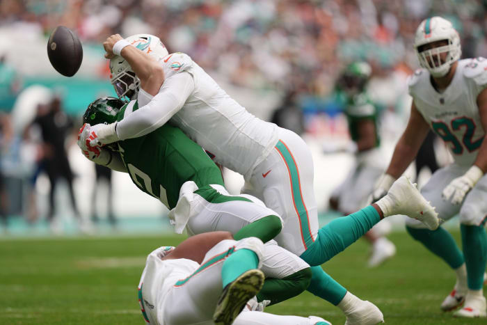 Miami Dolphins linebacker Bradley Chubb, top, and defensive tackle Christian Wilkins, bottom, hit New York Jets quarterback Zach Wilson (2) causing a fumble during the first half of an NFL game at Hard Rock Stadium