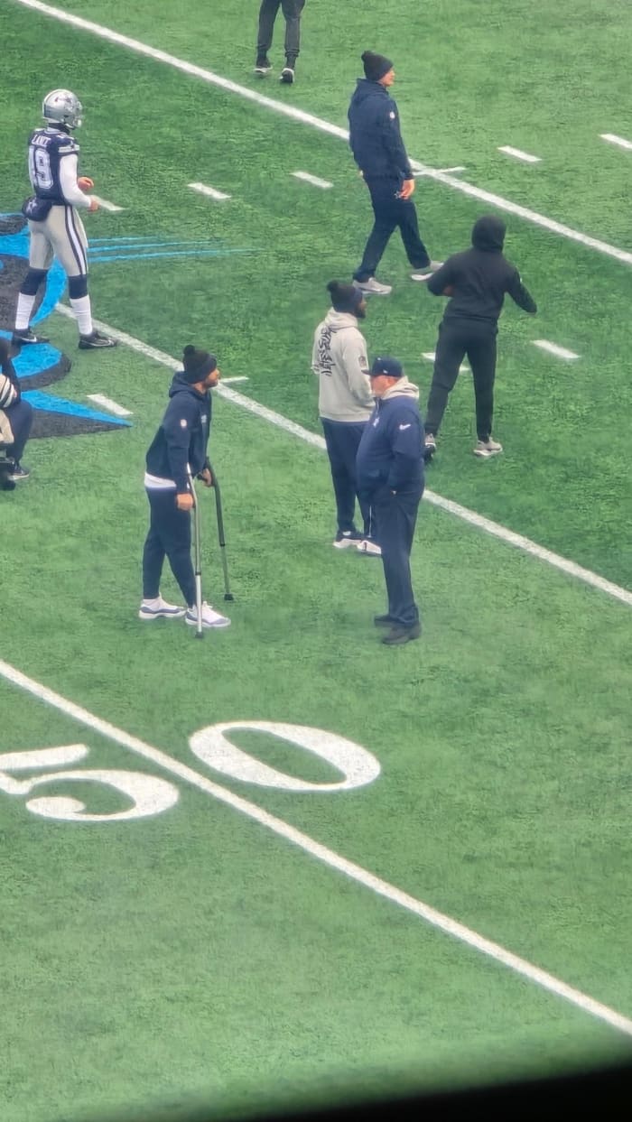 Dak Prescott on field with crutches